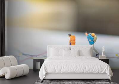 travel concept. two traveler male and female miniature figures with backpack walking on map. Wall mural