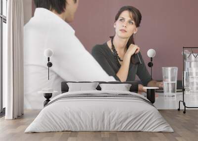 Beautiful young businesswoman with male colleague in discussion at office Wall mural