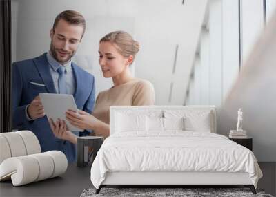 Bsinesswoman showing digital tablet to colleague in office Wall mural