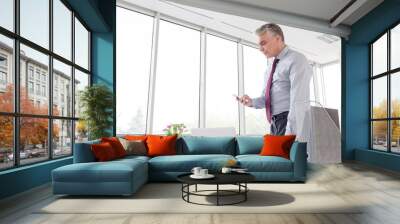 Businessman using smartphone in office Wall mural