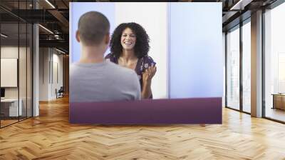 Casually dressed businesswoman talking to colleague in office Wall mural