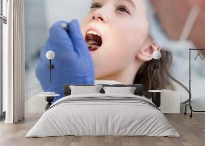 Doctor cleaning or pulling patient teeth in clinic Wall mural