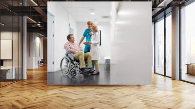 Doctor discussing medical result to patient sitting on wheel chair in clinic Wall mural