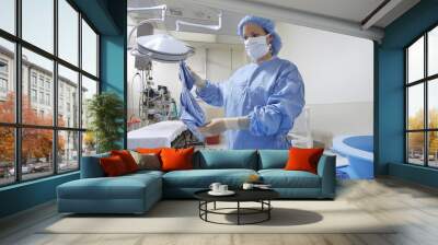 Female nurse preparing bed in operation theatre Wall mural