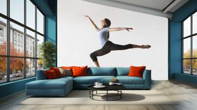 Full length of female ballet dancer leaping in mid air isolated on white background Wall mural