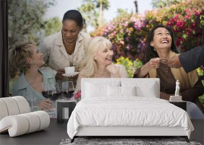 Happy multiethnic female friends enjoying dinner party in garden Wall mural