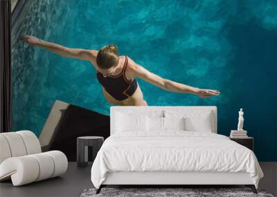 High angle view of a female swimmer ready to dive while standing at the edge of the springboard Wall mural