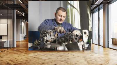 Mechanic working on motor in garage Wall mural