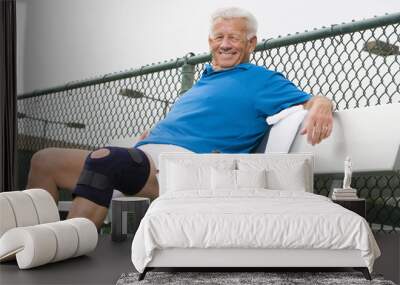 portrait of a happy senior man relaxing on bench after playing tennis Wall mural