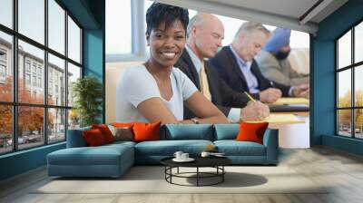 Portrait of a smiling businesswoman with multiethnic colleagues in conference room Wall mural