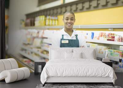 Portrait of a smiling male teenage supermarket employee Wall mural