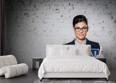 Portrait of beautiful young businesswoman holding open sign placard against brick wall Wall mural