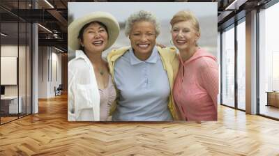 Portrait of cheerful female friends enjoying vacation at beach Wall mural