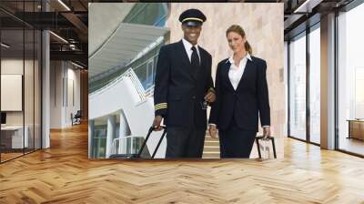 Portrait of happy pilot and flight attendant outside building Wall mural