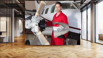 Portrait of young aeronautic engineer standing in front of an airplane propeller Wall mural