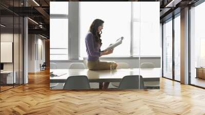 side view of a young businesswoman sitting on conference table Wall mural