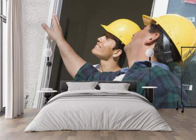 Two construction workers checking window at construction site Wall mural