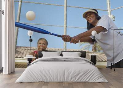 Two happy multiethnic female friends playing baseball Wall mural