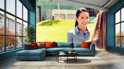 Young attractive businesswoman talking to her colleague
 Wall mural