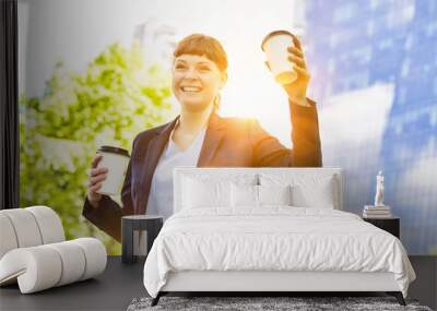 Young beautiful businesswoman holding two cups of coffee Wall mural