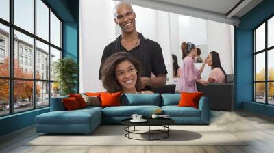 Young woman sitting on chair with hairstylist standing behind Wall mural