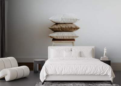 A wooden stool with three beige pillows in an empty light room Wall mural