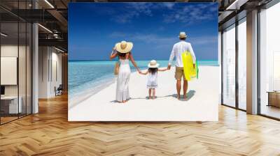 A family on summer vacation walks together on a tropical paradise beach in the Maldives with turquoise ocean and white sand Wall mural