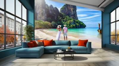 A happy couple stands on the beautiful beach of Railay, Krabi, Thailand, during their summer vacations Wall mural