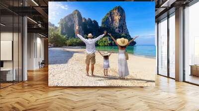 A happy family stands on the beautiful beach of Railay, Krabi, Thailand, during their summer vacations Wall mural