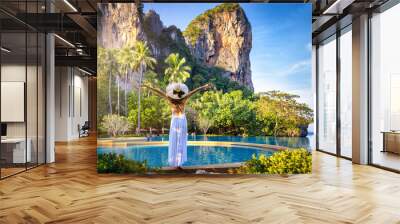 A summer travel concept with a woman in a white dress looking at the tropical paradise beach of Railay, Krabi, Thailand Wall mural