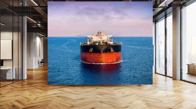 Aerial front view of a heavy crude oil tanker traveling over calm sea during sunset Wall mural