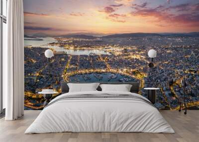 Aerial panorama of the illuminated Piraeus district in Athens, Greece, with Zea Marina and the ferry boat harbour in the background during evening time Wall mural