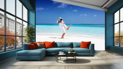 Happy, young couple in white summer clothes enjoying their vacation on a tropical beach Wall mural