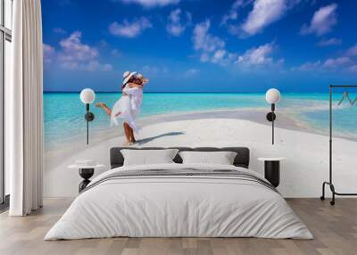 Happy couple in love is having fun and hugging on a sandbar with white sand and turquoise ocean Wall mural