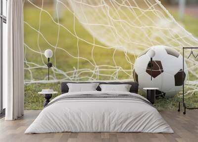 Soccer ball on grass and sun light. Wall mural