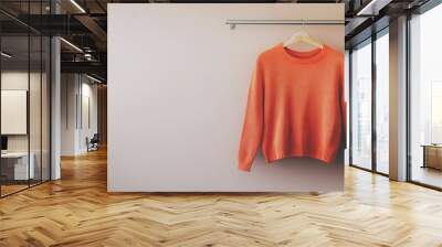 Orange shirt hanging on a clothes rack  Wall mural