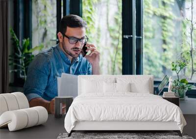 Corporate communication. Portrait of busy young male manager working remotely. Wall mural