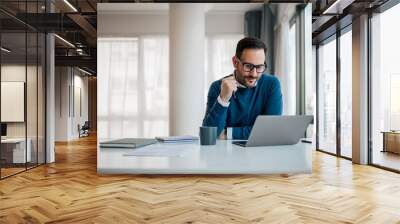 serious businessman working on laptop. male professional is planning strategy while sitting at offic Wall mural