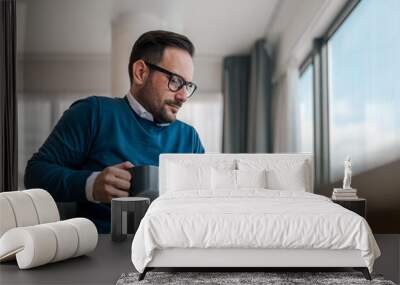 Serious professional having coffee while working at desk in corporate office Wall mural