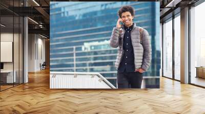 Black man, phone call and walking for city buildings, 5g network connection and travel. Happy business student person with backpack for mockup and talking on smartphone for communication in New York Wall mural