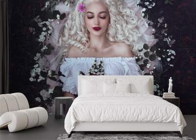 Sleeping beauty. Enchanted Princess lies in a coffin in flowers with a bouquet. Sleeping in the dark woods. Wall mural