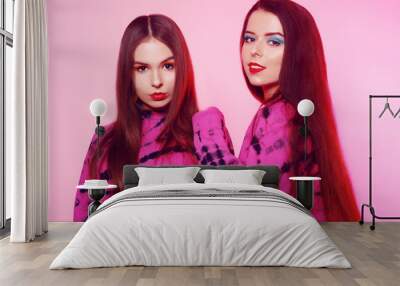 2 girls in the same things with bright makeup. Brunette girls, sisters, girlfriends, twins. Women's power, March 8, Women's Day. Clothing store for teens. Pink color in clothes Wall mural