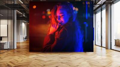 Sexy young woman posing over night city dramatic neon background Wall mural