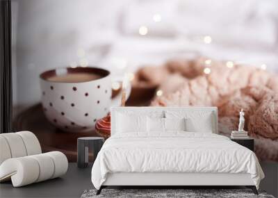 Cupcake with cup of coffee with knitted cloth on wooden tray in bed close up. Good morning. Wall mural