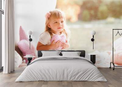 Cute baby girl holding heart pillow in bed. Childhood. Good morning. Wall mural