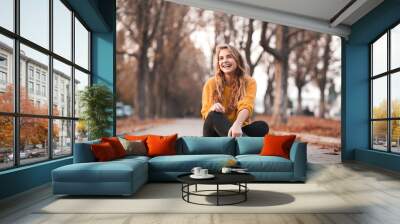 Smiling teenage girl 14-16 year old wearing casual autumn clothes sitting in park. Looking away. Happiness. Wall mural