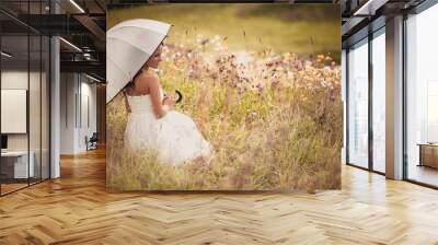 beautiful bride with white umbrella in the field at summer time waiting for groom in warm colors Wall mural