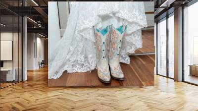 White lace dress of the bride is paired with white embroidered cowgirl boots for a western wedding ceremony Wall mural