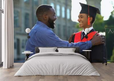 Afro-american father feeling glad graduating son university mantle, achievement Wall mural