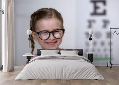 Cute happy girl in eyeglasses laughing into camera, comfortable eyewear Wall mural